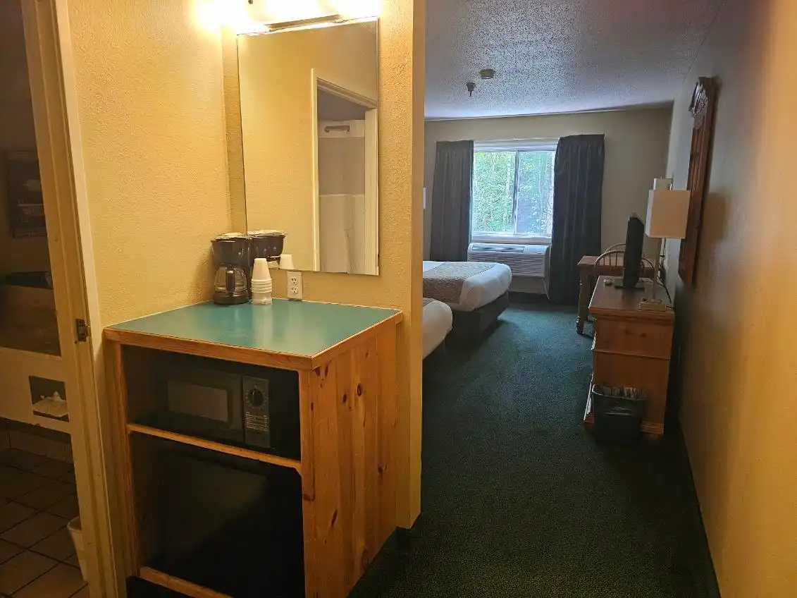 The in-room counter with a microwave and coffeemaker beside the vanity mirror